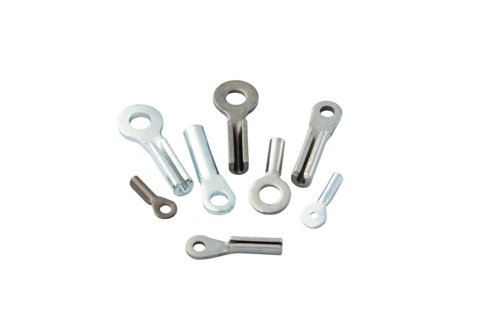 Custom cable assemblies with stamped eye end fittings. Group of stamped eye fittings in assorted sizes on a light background.