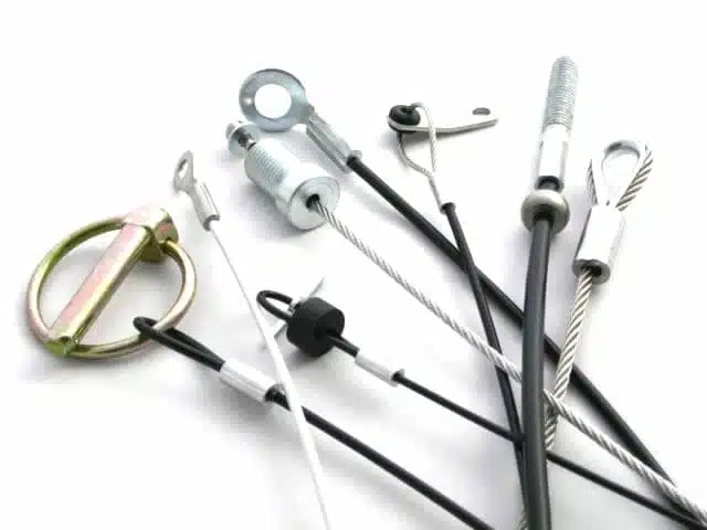 lanyards. Short cables, mix of coated (black) and bare, with end fittings like linch pins, stamped eyes, loops, and stops.