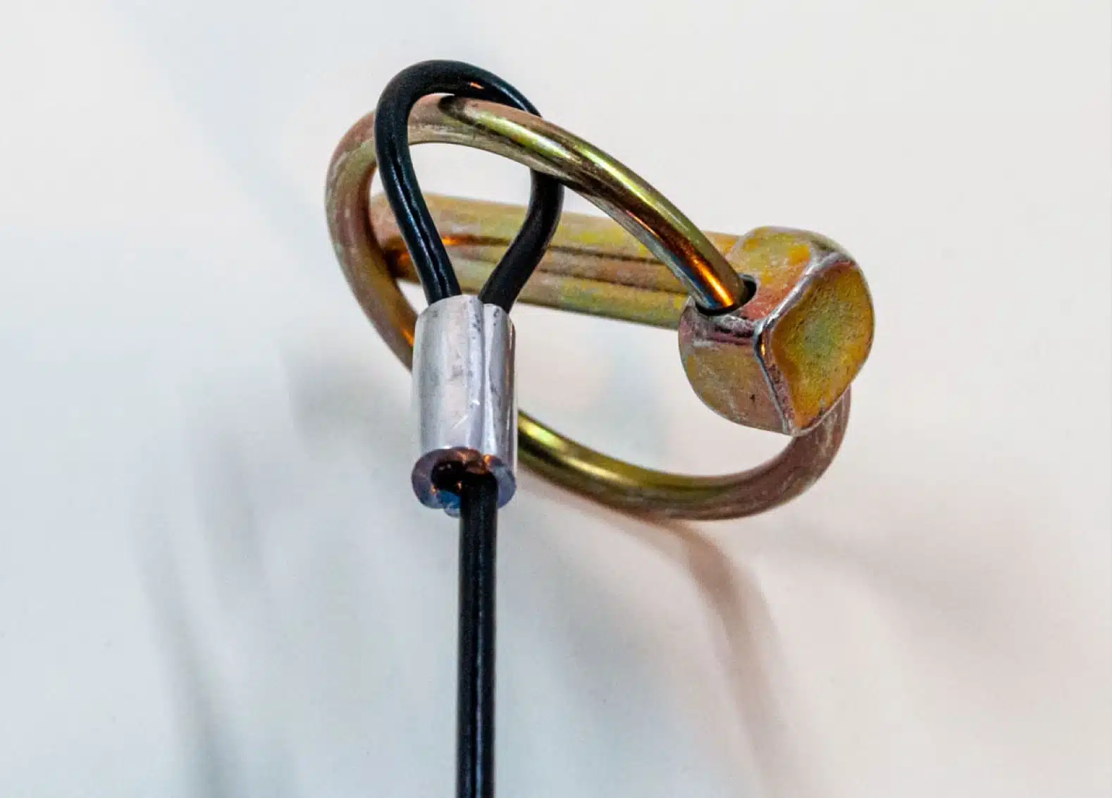 Wire rope lanyard attached to a metal ring.