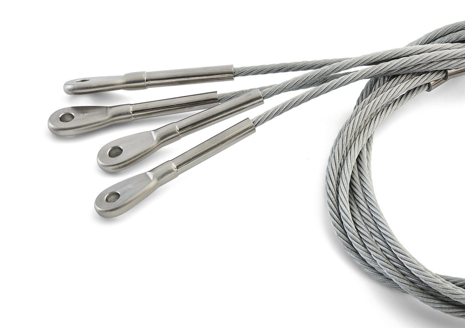 Group of wire rope assemblies with metal eye terminals on a light background.